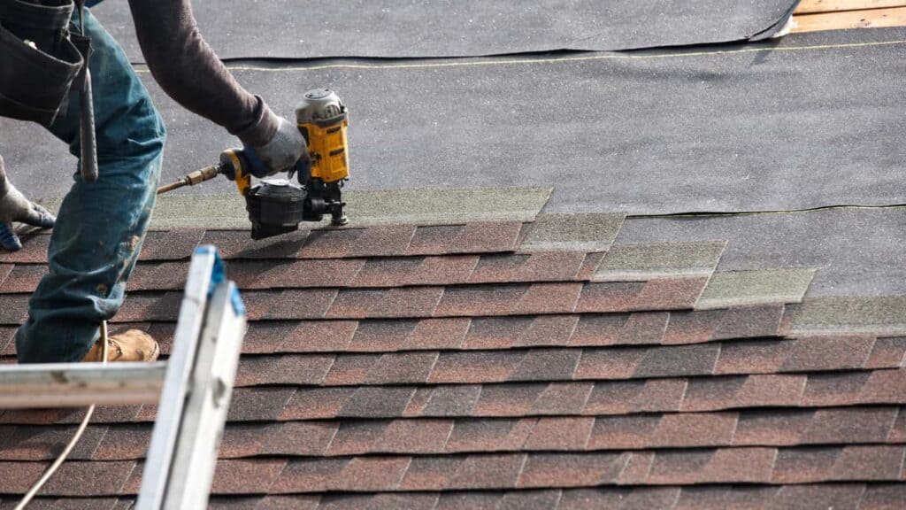 roofer showing how to repair shingles on a roof
